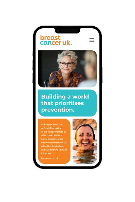 A mobile phone showing the Breast Cancer UK homepage featuring prevention messaging and images of smiling women.