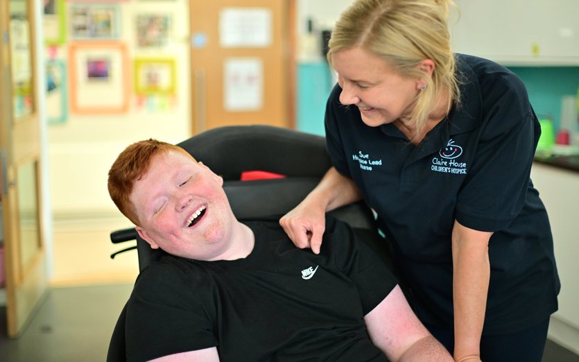 Claire House working smiling with boy in wheelchair