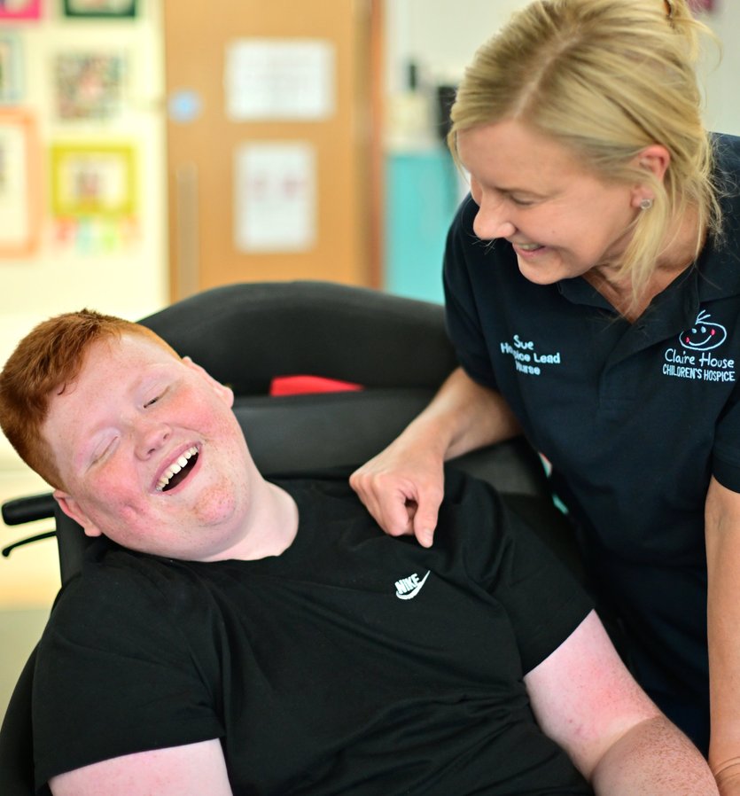 Claire House working smiling with boy in wheelchair