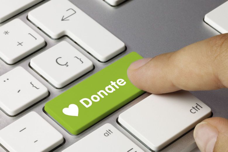 Person pressing the donate button on a keyboard