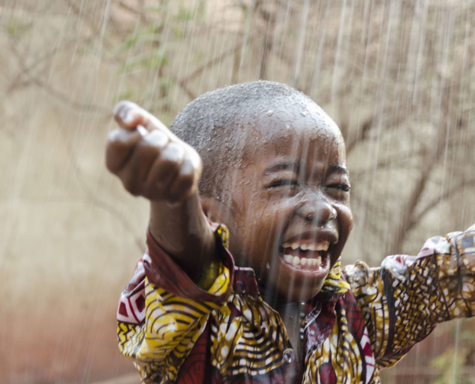 Smiling child in the rain.