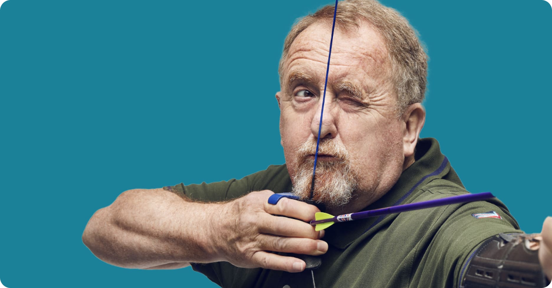 Man aiming down sight of bow ready to fire arrow
