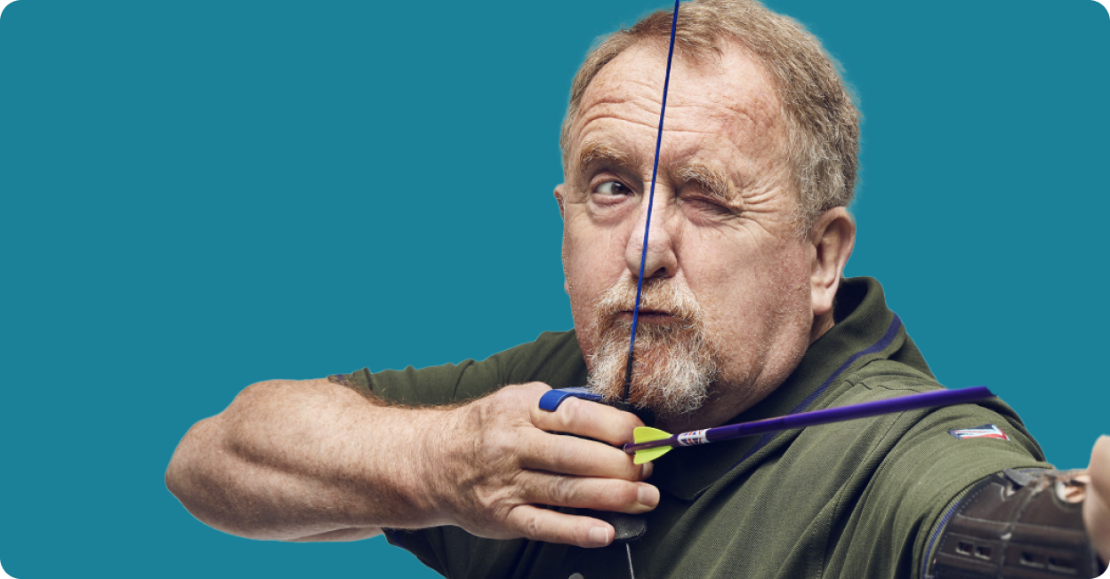 Man aiming down sight of bow ready to fire arrow