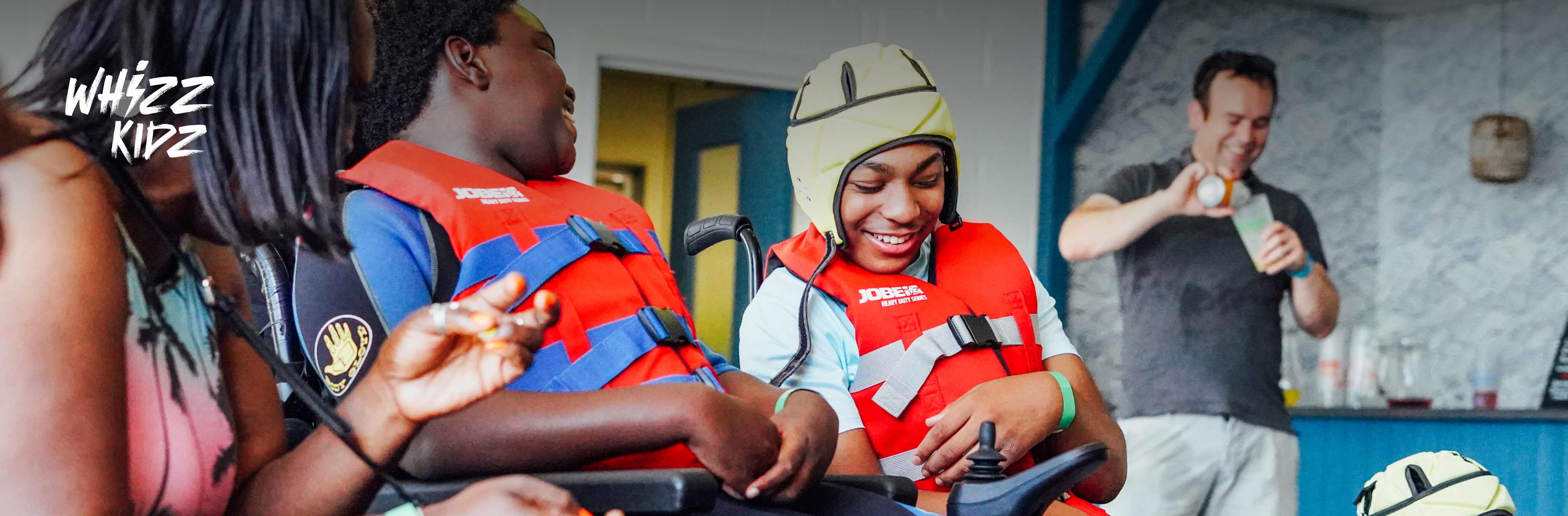 Two wheelchair users smiling.
