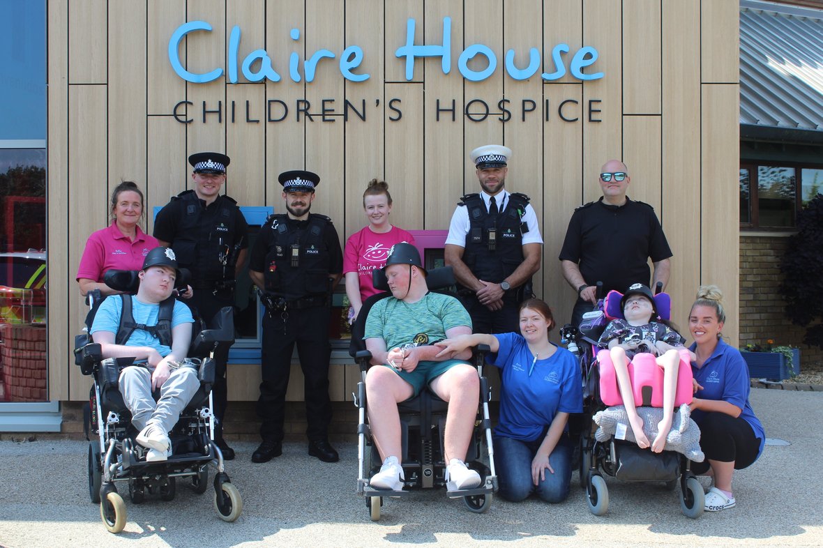 Group of wheelchair-bound people in front of Claire's House Hospice