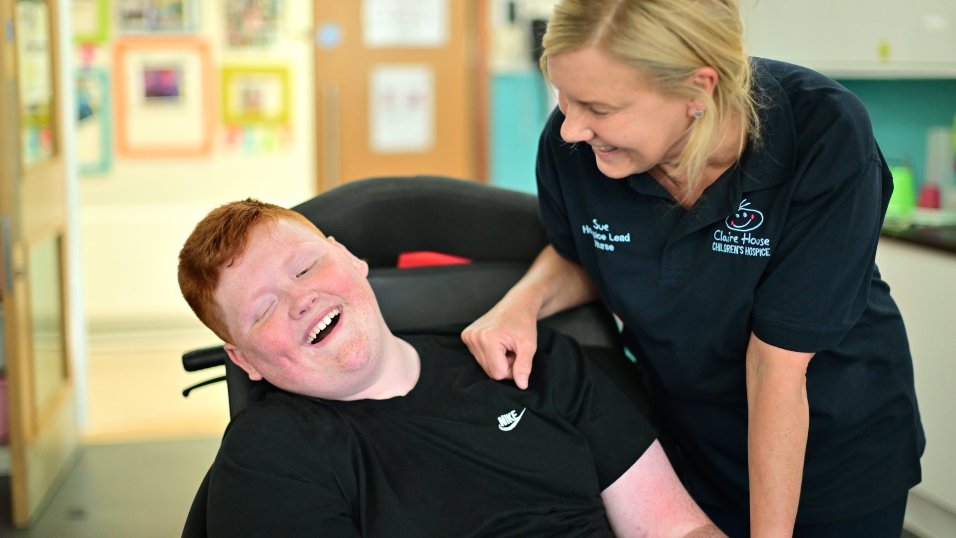 Claire House working smiling with boy in wheelchair
